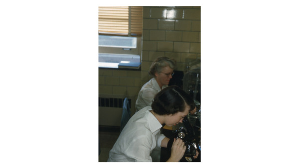 Female students look through a microscope